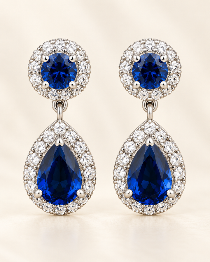 Blue halo pear drop earrings — clean cream portrait product image
