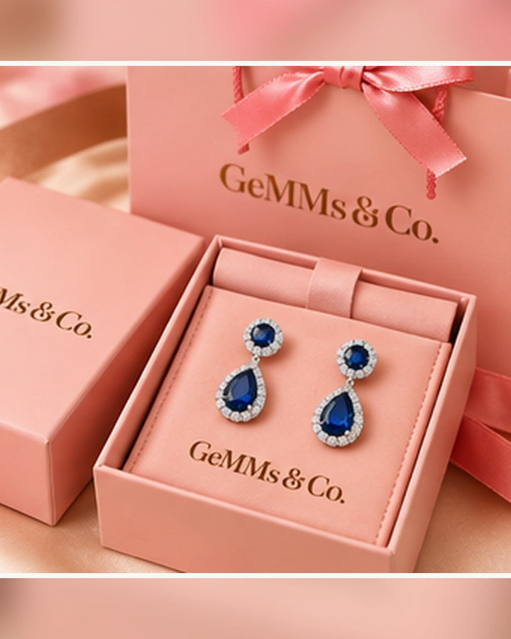 Blue halo pear drop earrings — GeMMs & Co. luxury packaging portrait image