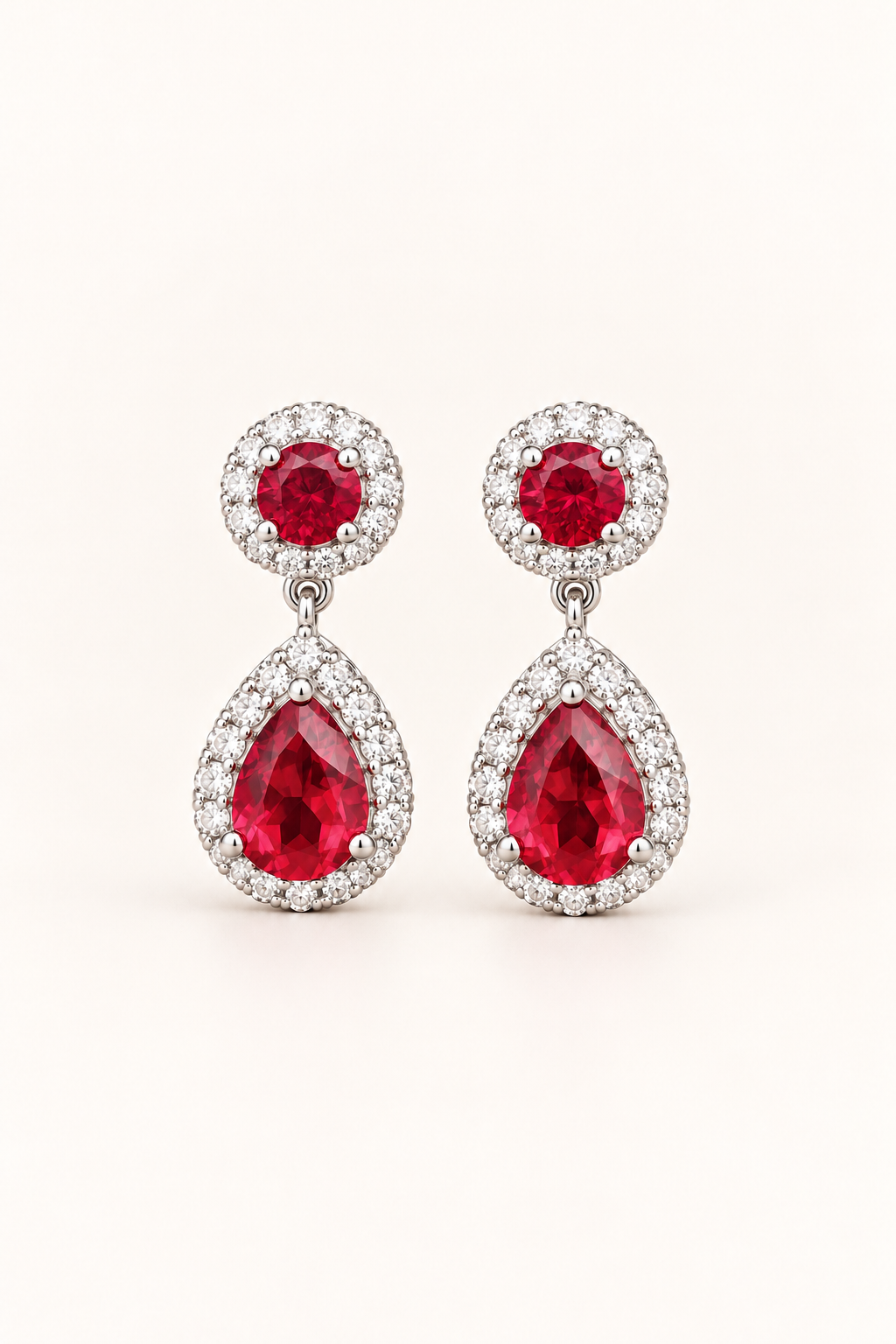 Red halo pear drop earrings in 9ct white gold on a plain cream background