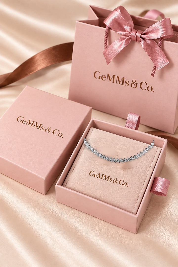 18.58ct white-gold pear-cut diamond tennis necklace shown in GeMMs & Co pink luxury packaging, styled mockup #metal_9ct-white-gold