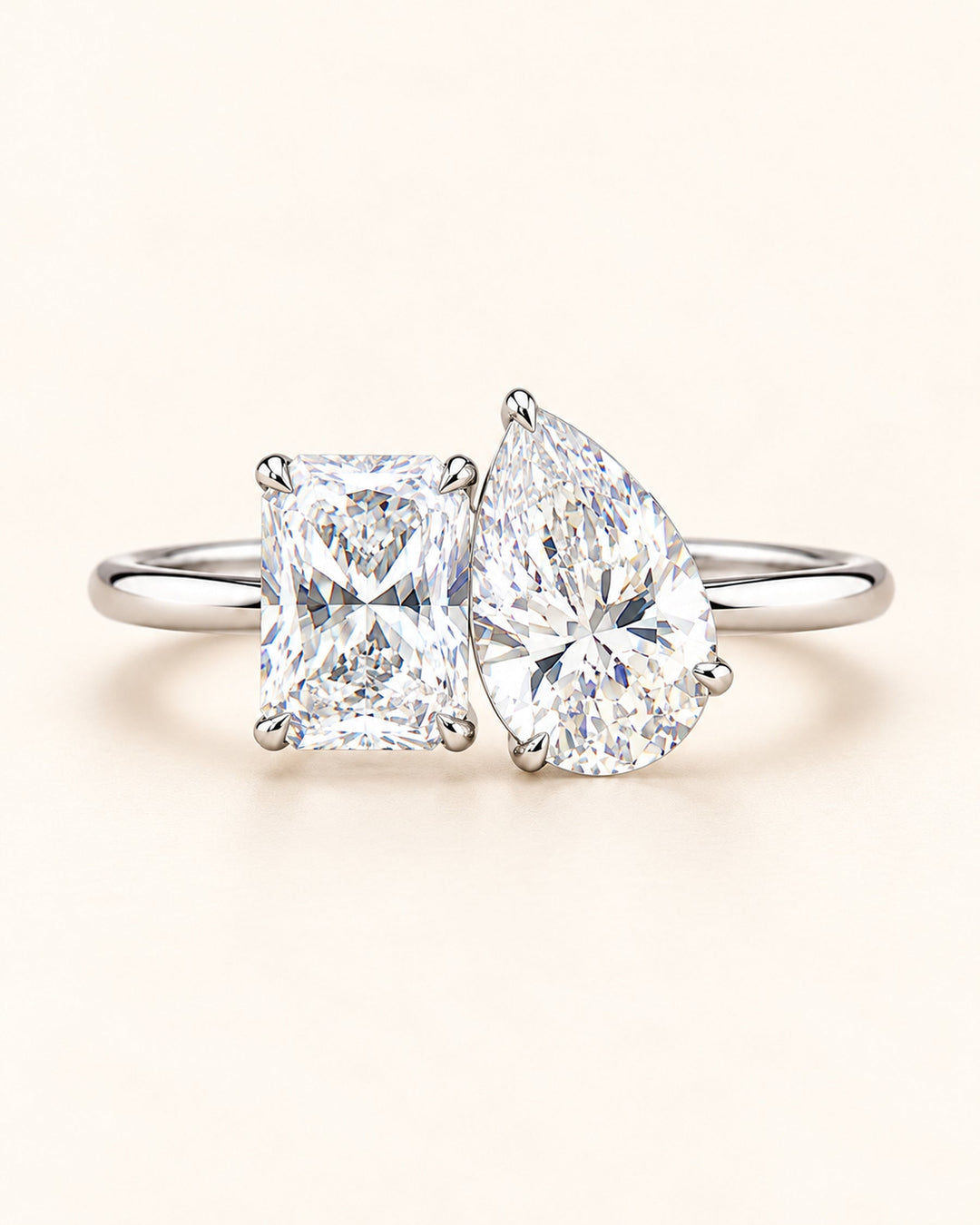 Pear and radiant Toi et Moi diamond ring on cream #metal_18ct-white-gold