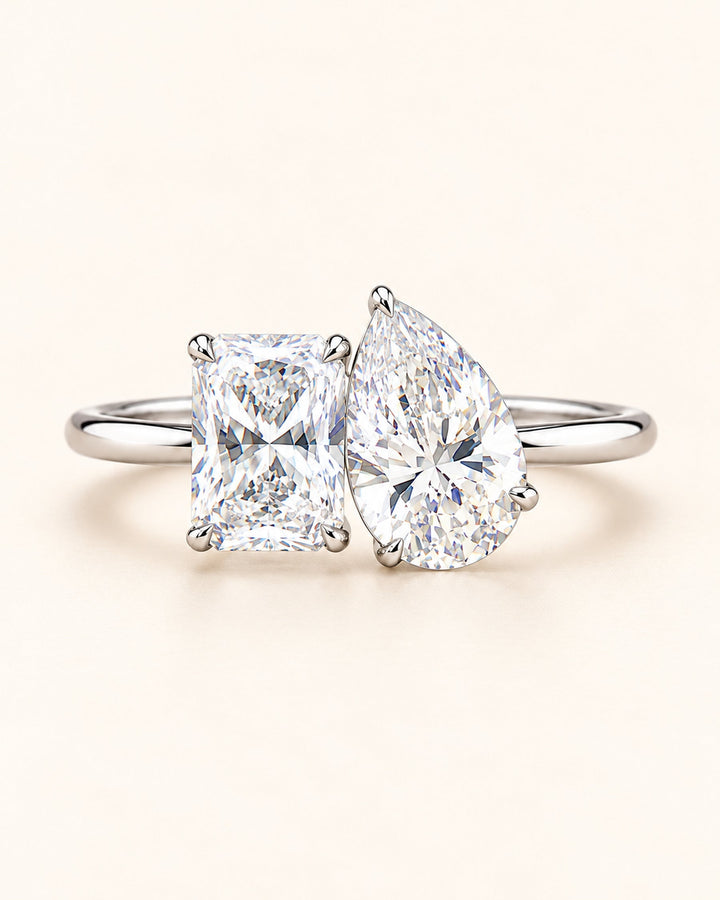 Pear and radiant Toi et Moi diamond ring on cream #metal_18ct-white-gold