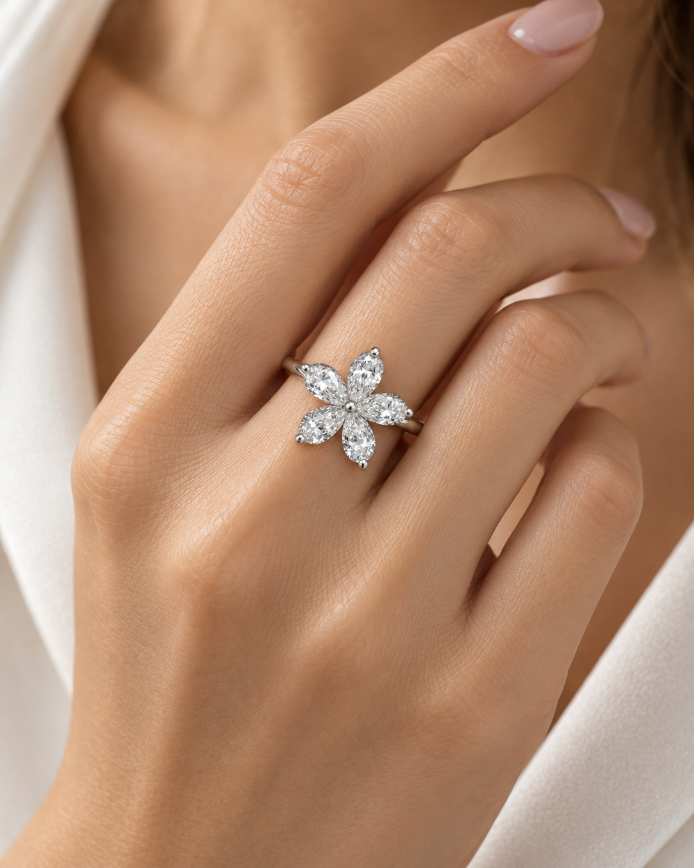 Five pear-shaped lab-grown diamond petals flower ring worn on model hand in 18ct white gold — illustrative lifestyle image