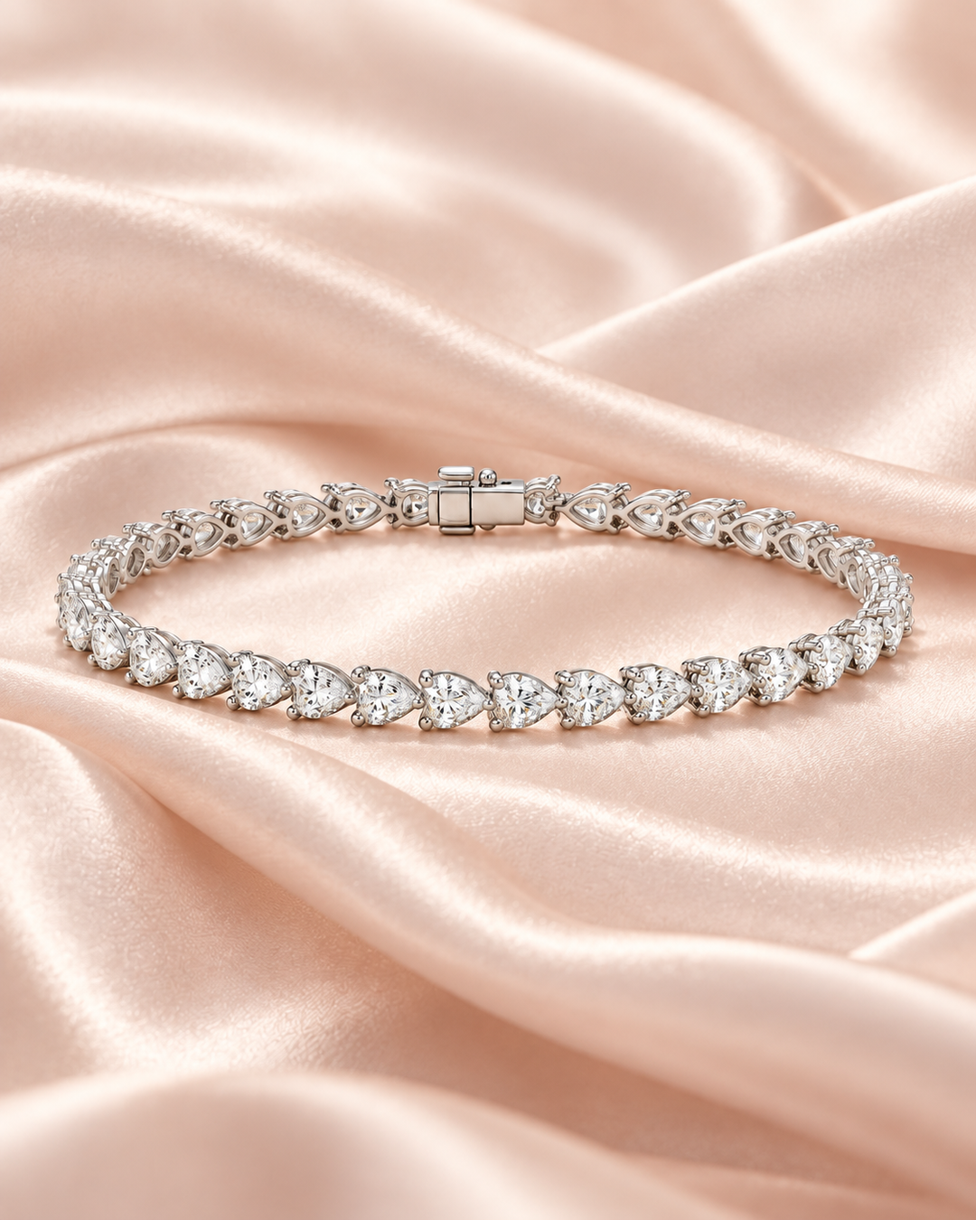 Pear shape lab-grown diamond tennis bracelet on soft blush satin