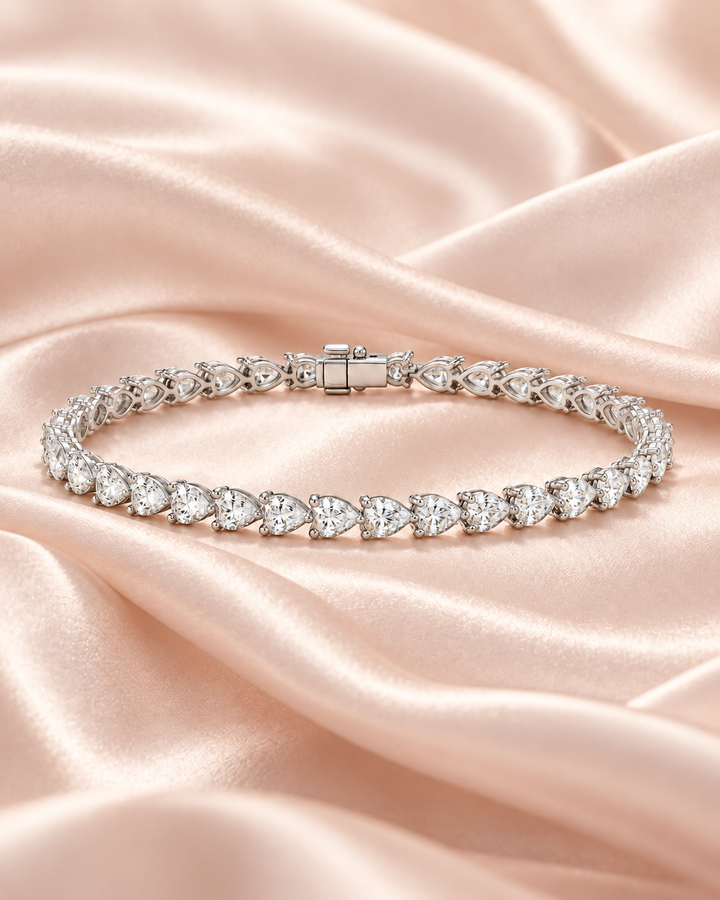 Pear shape lab-grown diamond tennis bracelet on soft blush satin