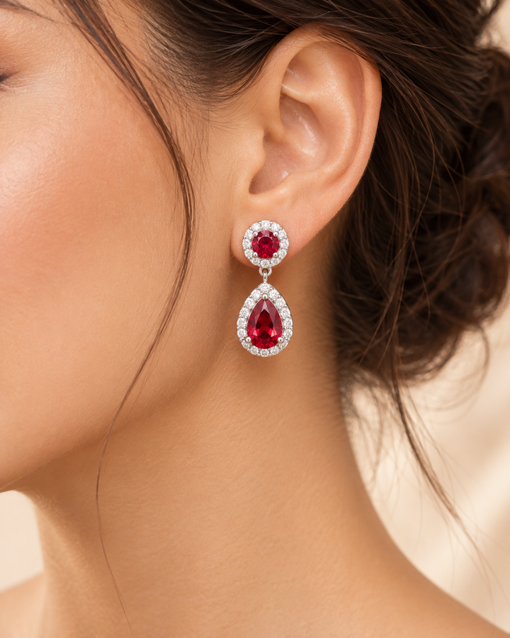 Red halo pear drop earrings — realistic on-ear portrait image